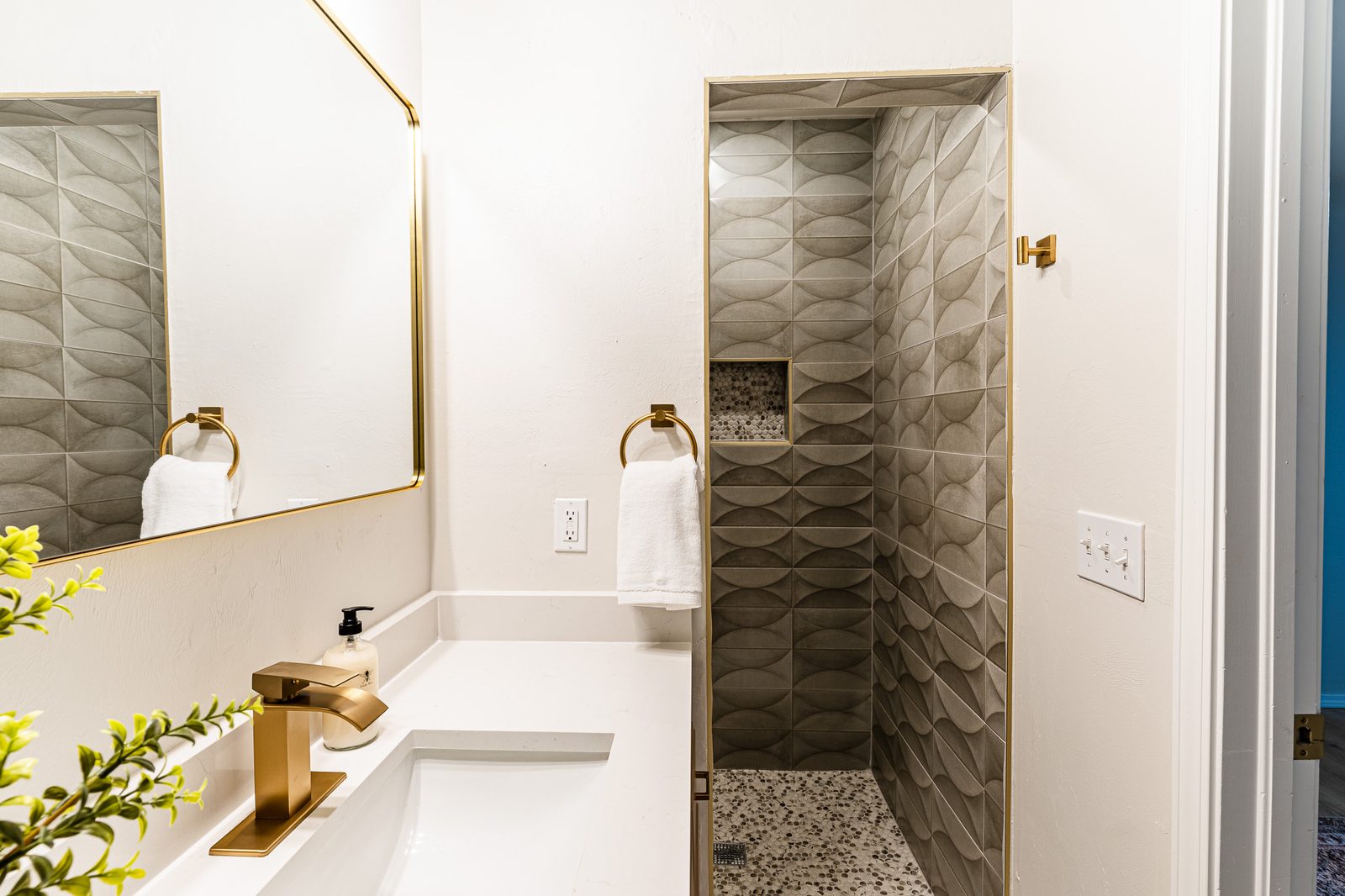 Primary bathroom with gold faucet, quartz vanity and tiled walk-in shower, listing photo in Edmond, OK